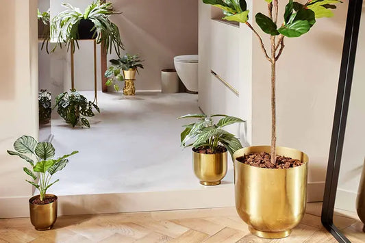 Verschiedene Kunstpflanzen in goldenem Übertopf mit toller Abdeckung für den Sockel der Kunstpflanzen.